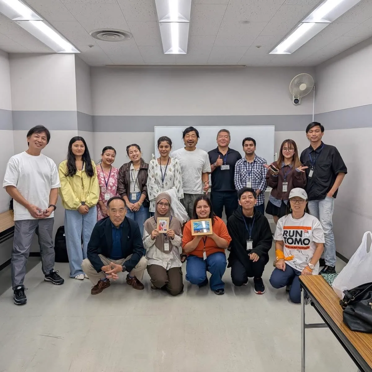 第1回NIJIカフェ横須賀の集合写真。いろいろな国の参加者と地域・企業のみなさんが笑顔で並んでいる